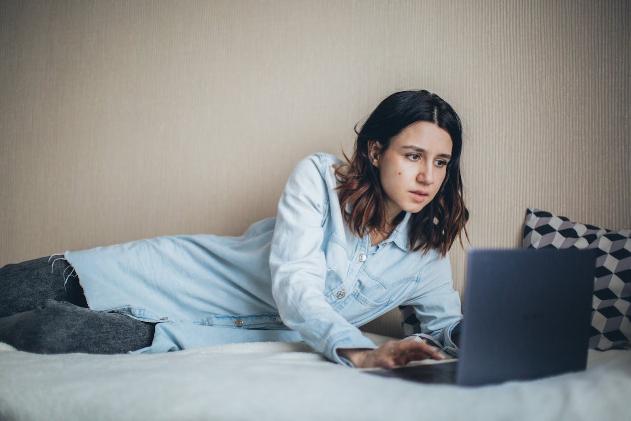 Kvinna med laptop hemma planerar flytten — när ska man adressändra?
